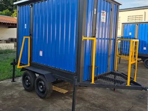 Unidade compacta azul com guarda-corpo amarelo e escadas, estacionada em pátio claro