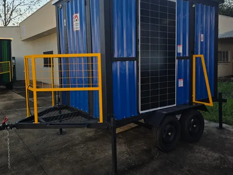 Unidade azul com placa solar na porta e acessos amarelos, vista em ângulo no pátio