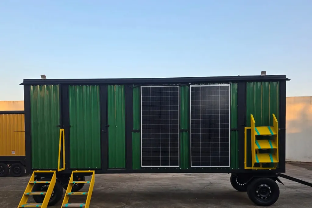 Área de vivência longa verde com painéis solares e acessos amarelos